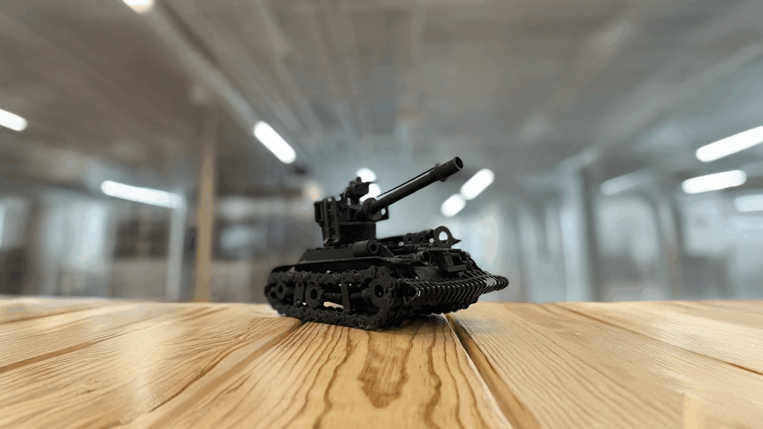 Miniature black tank model on wooden surface